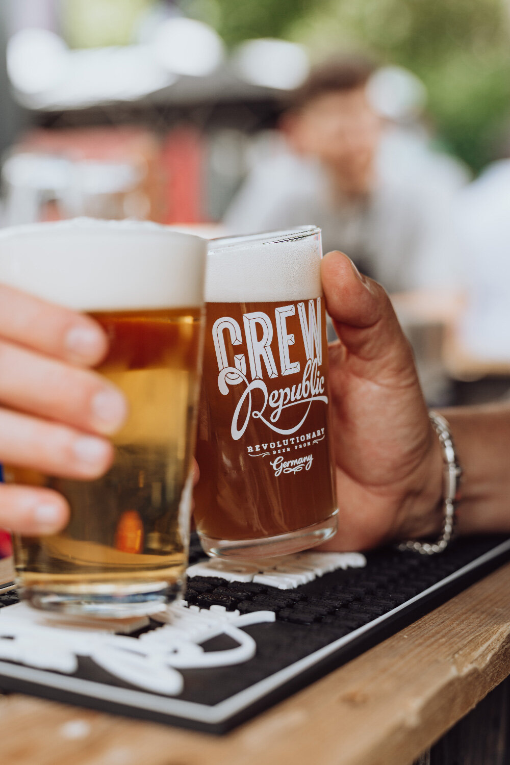 Anstossen zweier Gläser mit Crew Republic Bier