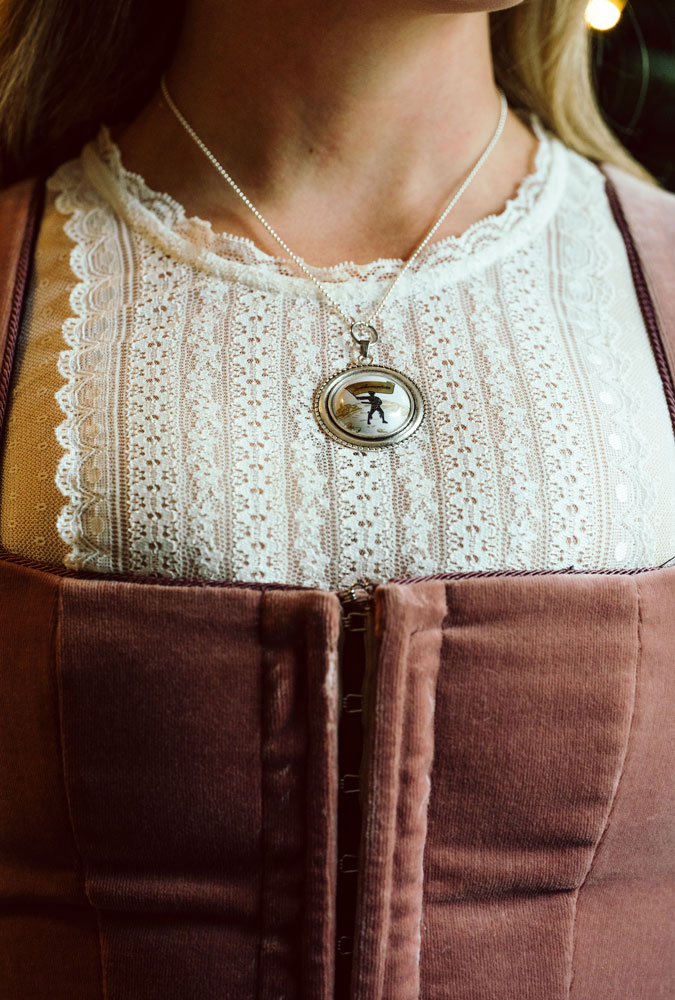 Eine Frau trägt einen Halskette mit Charivari von Schwarzbräu um den Hals